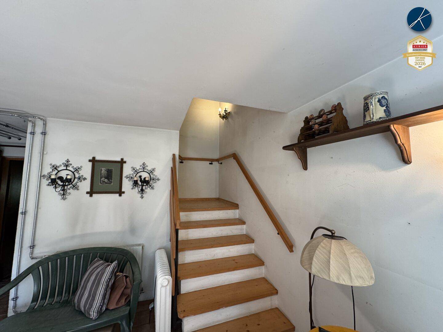Treppenaufgang mit Holzstufen und Geländer in einem traditionellen Haus.