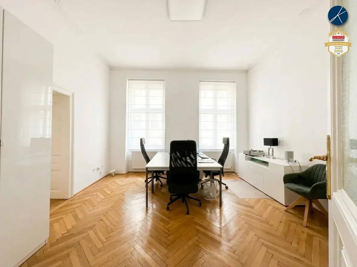 Helles Büro mit klassischem Fischgrätparkett und hohen Decken, ideal für eine professionelle Arbeitsumgebung.
