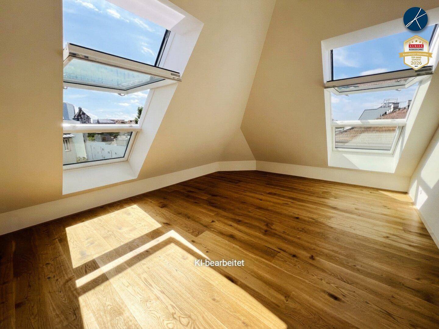 Heller Raum im Dachgeschoss mit Holzboden und großen Dachfenstern, die den Raum erhellen.