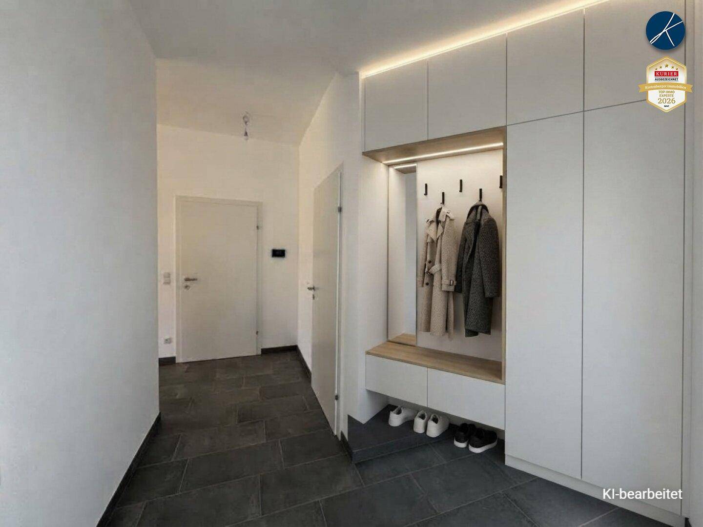 Moderner Eingangsbereich mit integriertem Garderobenschrank, indirekter Beleuchtung und dunklen Fliesen.
