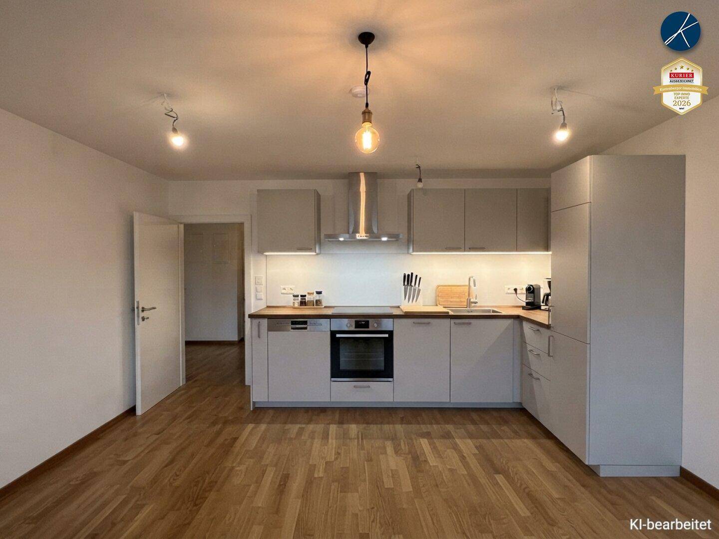 Moderne Einbauküche in Grau mit Holzarbeitsplatte und integrierten Geräten.