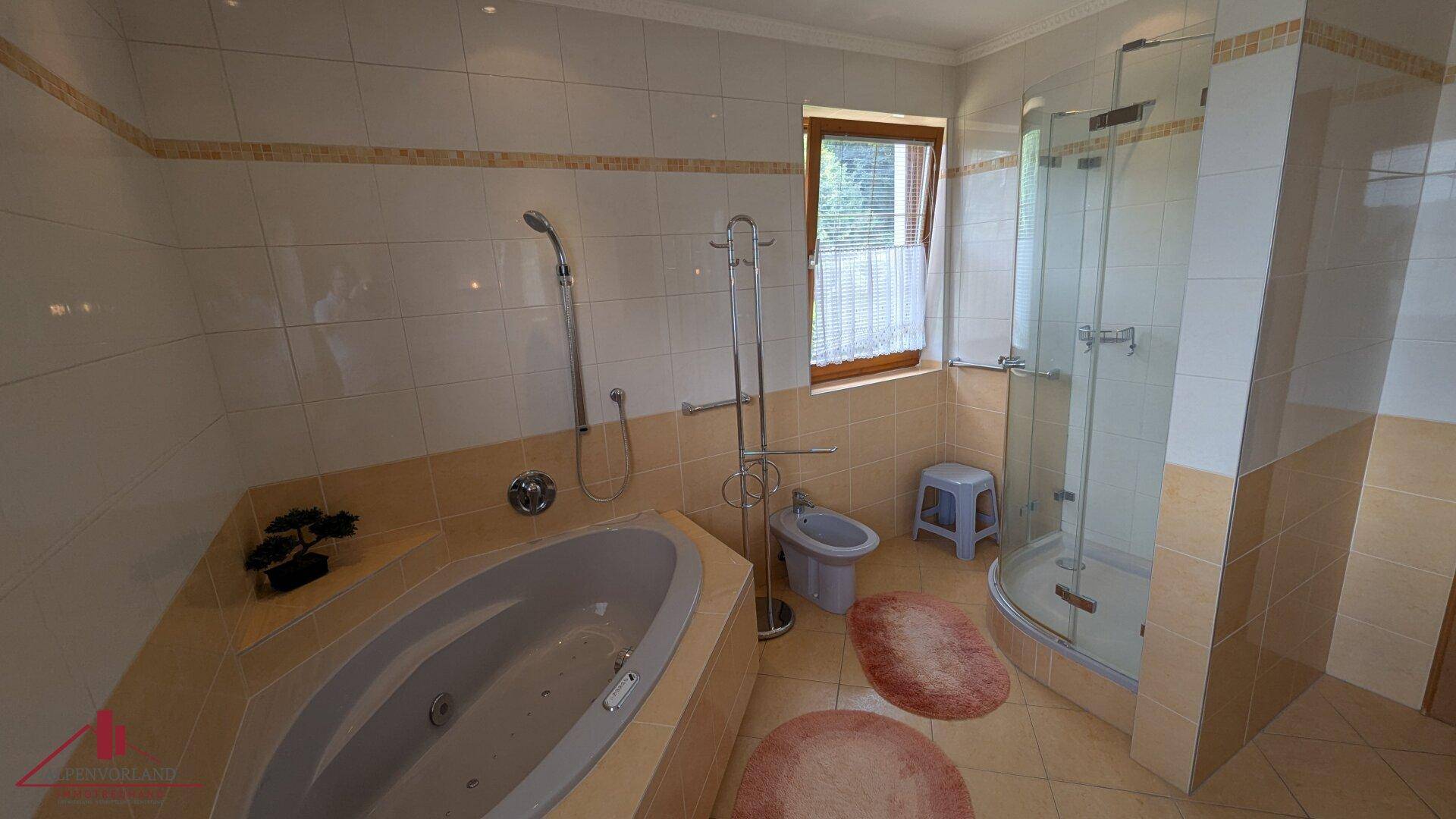 Geräumiges Badezimmer mit Eckbadewanne, separater Dusche und Bidet, hell gefliest.