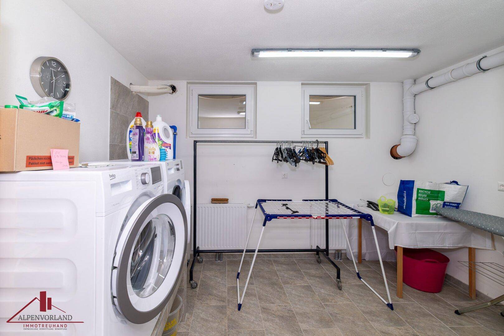 Praktischer Hauswirtschaftsraum mit Waschmaschine, Trockner und Platz zum Wäschetrocknen.