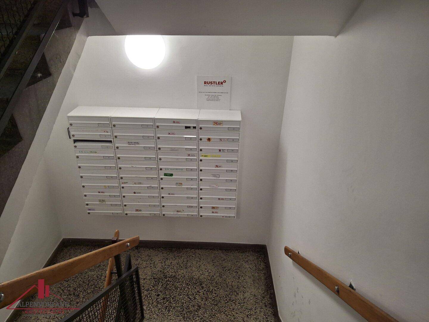 Treppenhaus mit Briefkästen und Terrazzoboden, typisch für ein Mehrfamilienhaus.