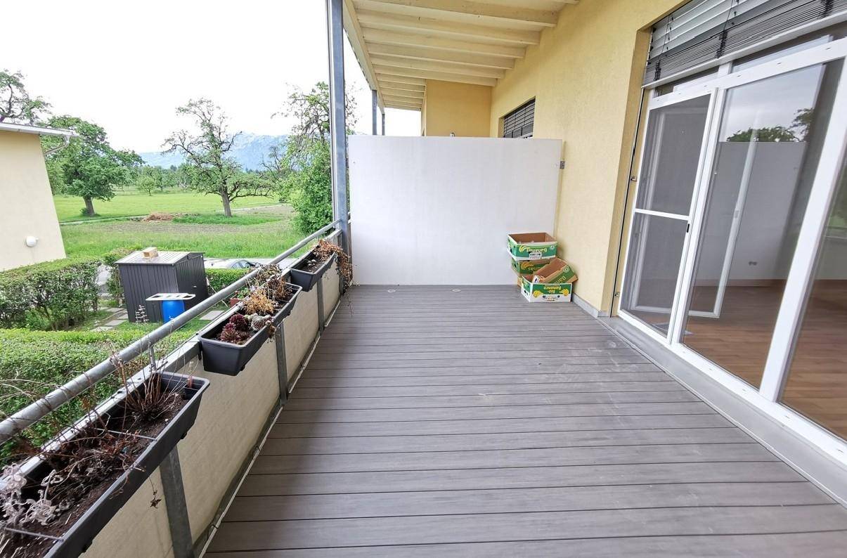 Geräumiger Balkon mit Holzdielenboden und weitem Blick ins Grüne und auf die Berge.
