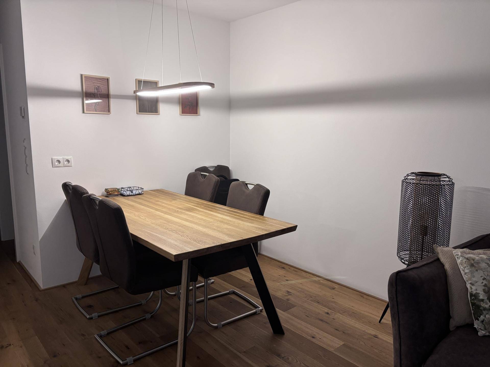 Essbereich mit Holztisch und modernen Stühlen, Teil eines offenen Wohnkonzepts.