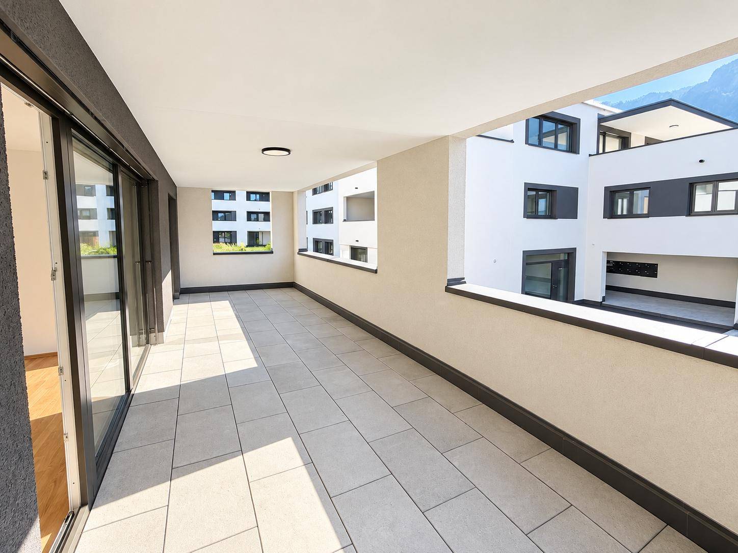 Lange Loggia mit Blick auf die moderne Architektur des Wohnkomplexes.