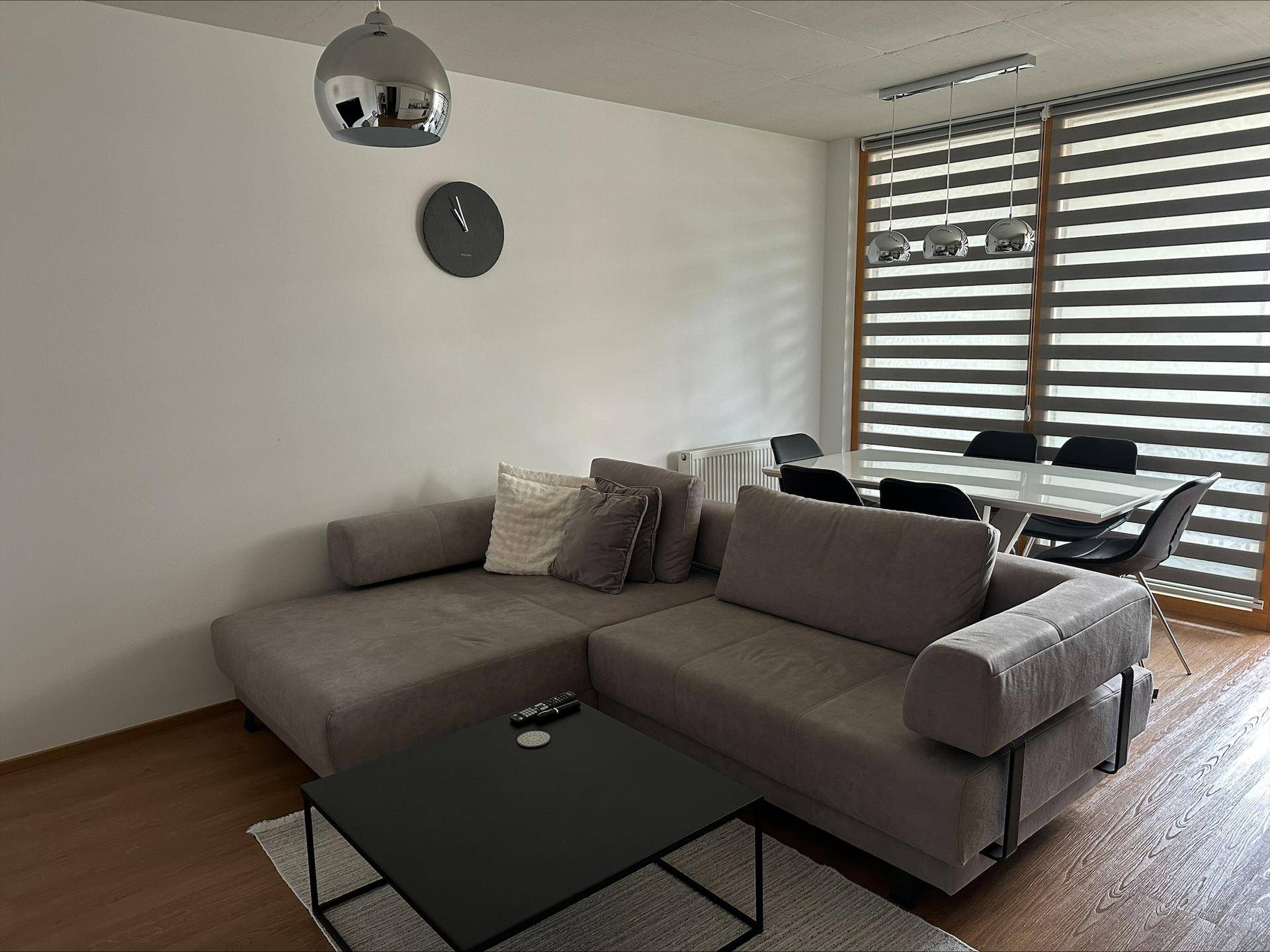 Gemütlicher Wohn- und Essbereich mit Ecksofa, Couchtisch und Esstisch am Fenster.