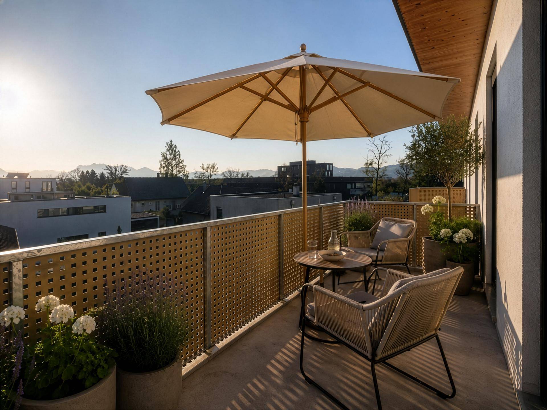 Gemütlicher Balkon mit Sitzgelegenheiten, Sonnenschirm und Blick auf die Berge.