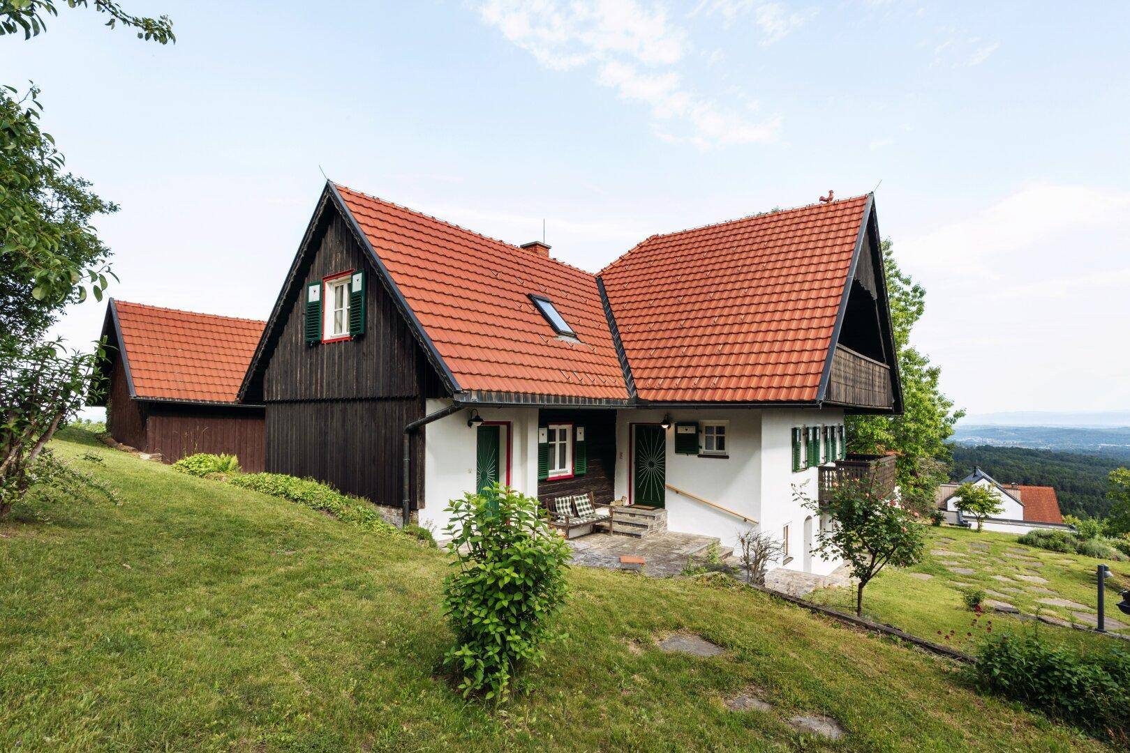 Vorderansicht des traditionellen Hauses mit Eingangsbereich und weitem Blick über die Landschaft.