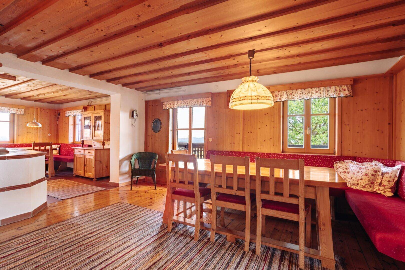 Geräumiger Wohn- und Essbereich mit Holzbalkendecken, großem Esstisch und traditioneller Einrichtung.