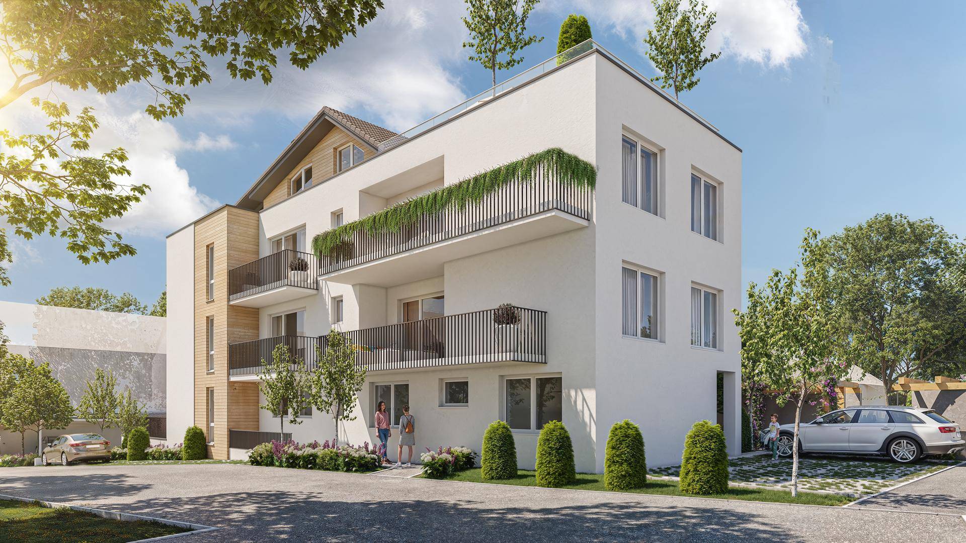 Seitenansicht des modernen Wohngebäudes mit mehreren Balkonen und gepflegter Außenanlage sowie Parkplätzen.