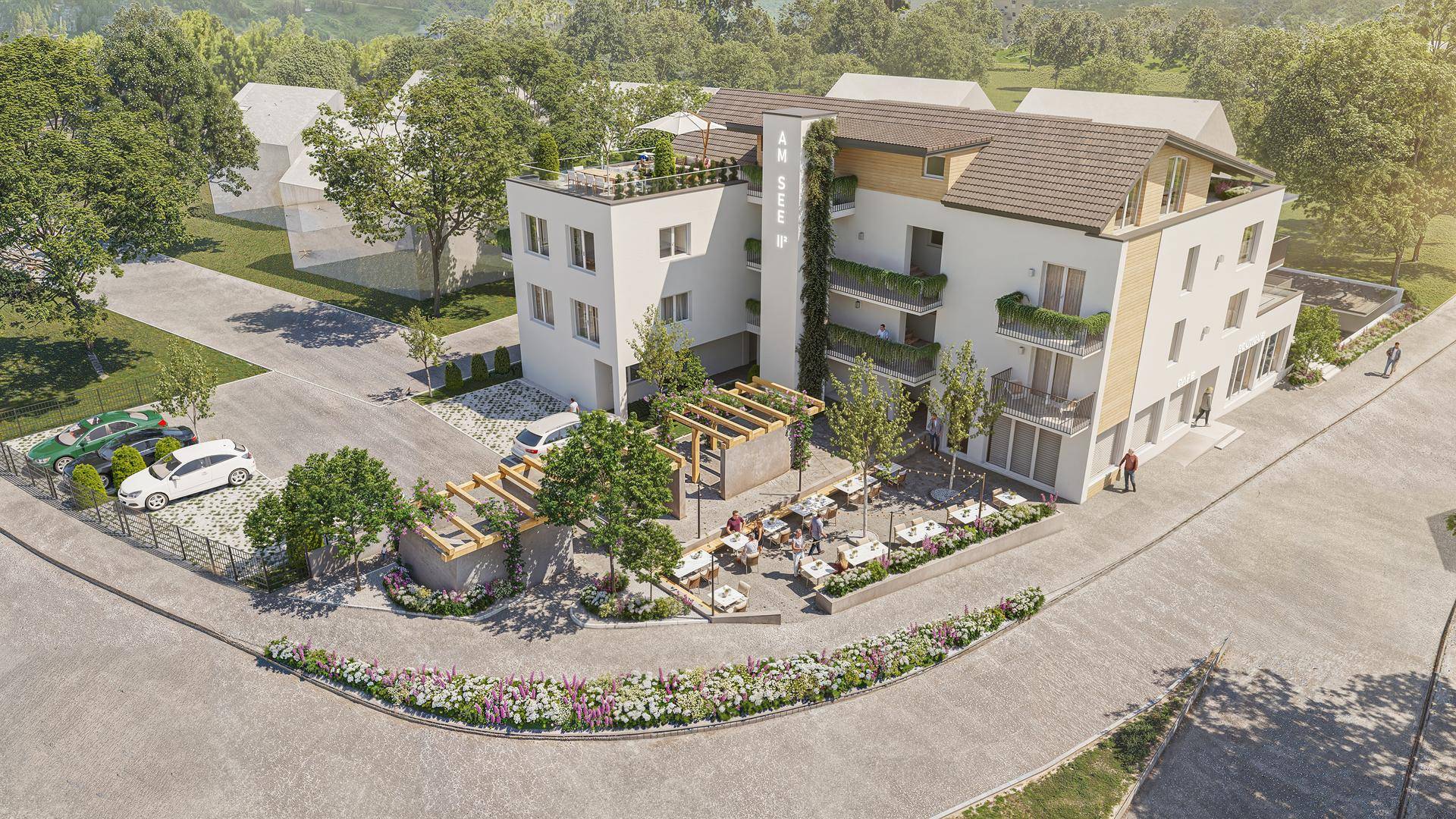 Vogelperspektive des Neubaus mit Außenbereich für Gastronomie, Pergola und umliegender gepflegter Grünfläche.