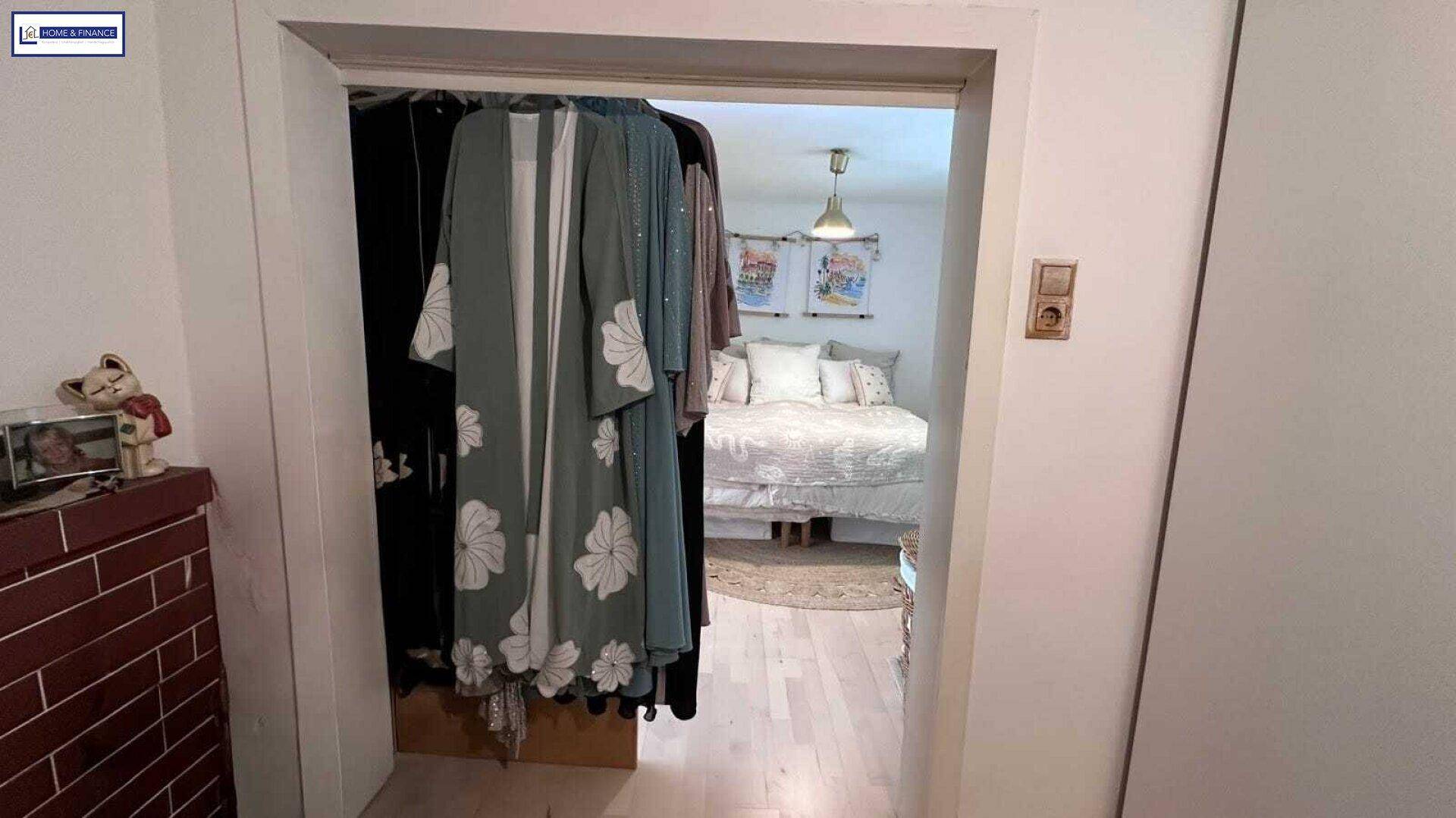 Blick durch den Türrahmen in ein gemütliches Schlafzimmer mit hellem Bett und Dekoration.
