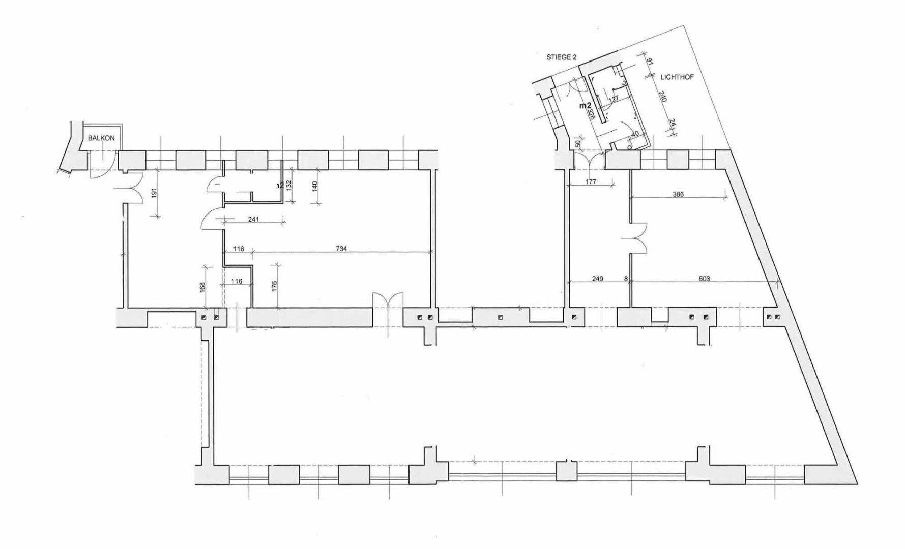 Grundrissplan mit mehreren Räumen, einem Balkon und einem Lichthof.