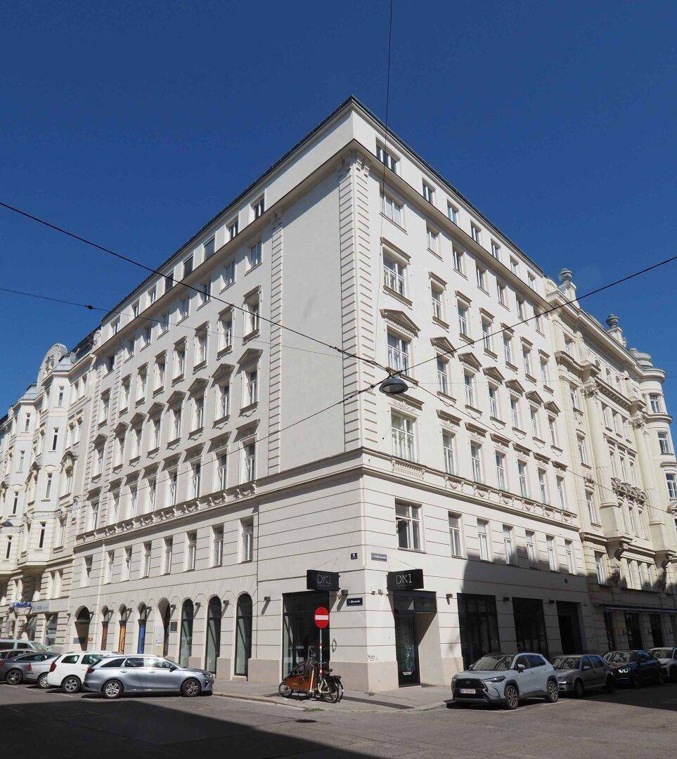 Historisches Eckgebäude mit klassischer Architektur und vielen Fenstern in der Stadt.