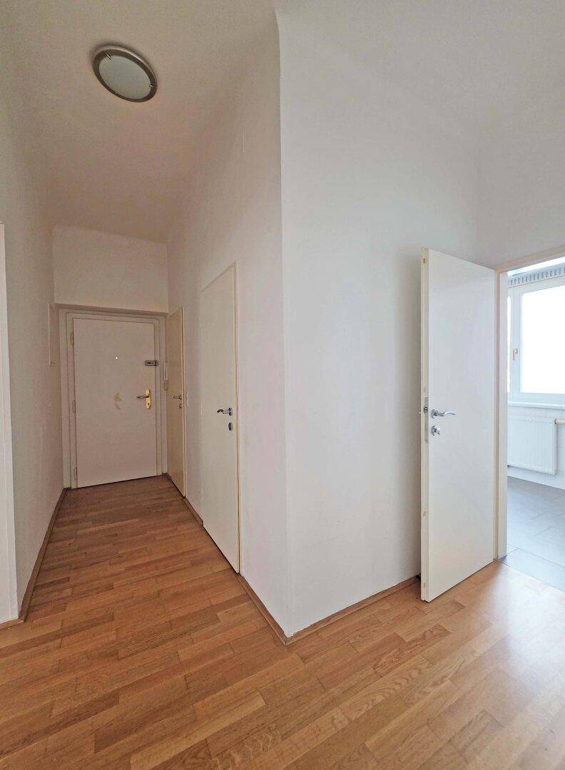 Heller Eingangsbereich mit Holzboden und Zugang zu verschiedenen Räumen.
