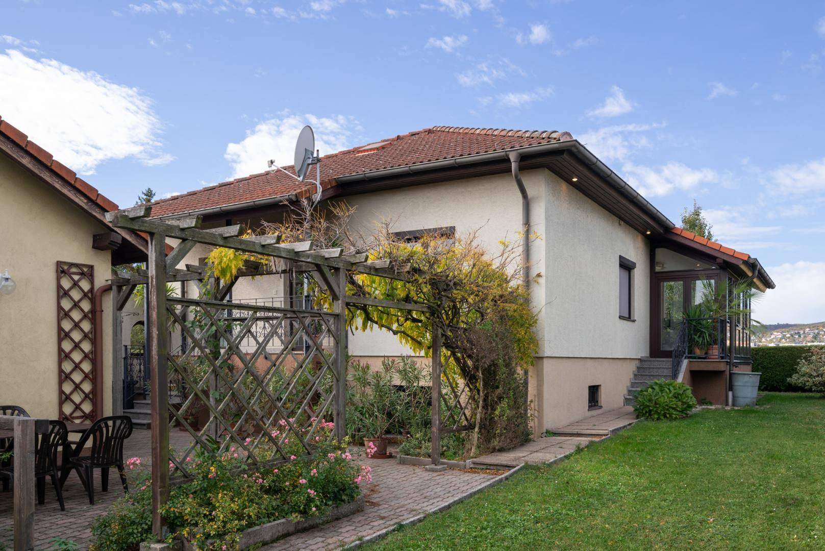 Seitenansicht des Hauses mit Garten, Terrasse und Zugang zum Wintergarten.