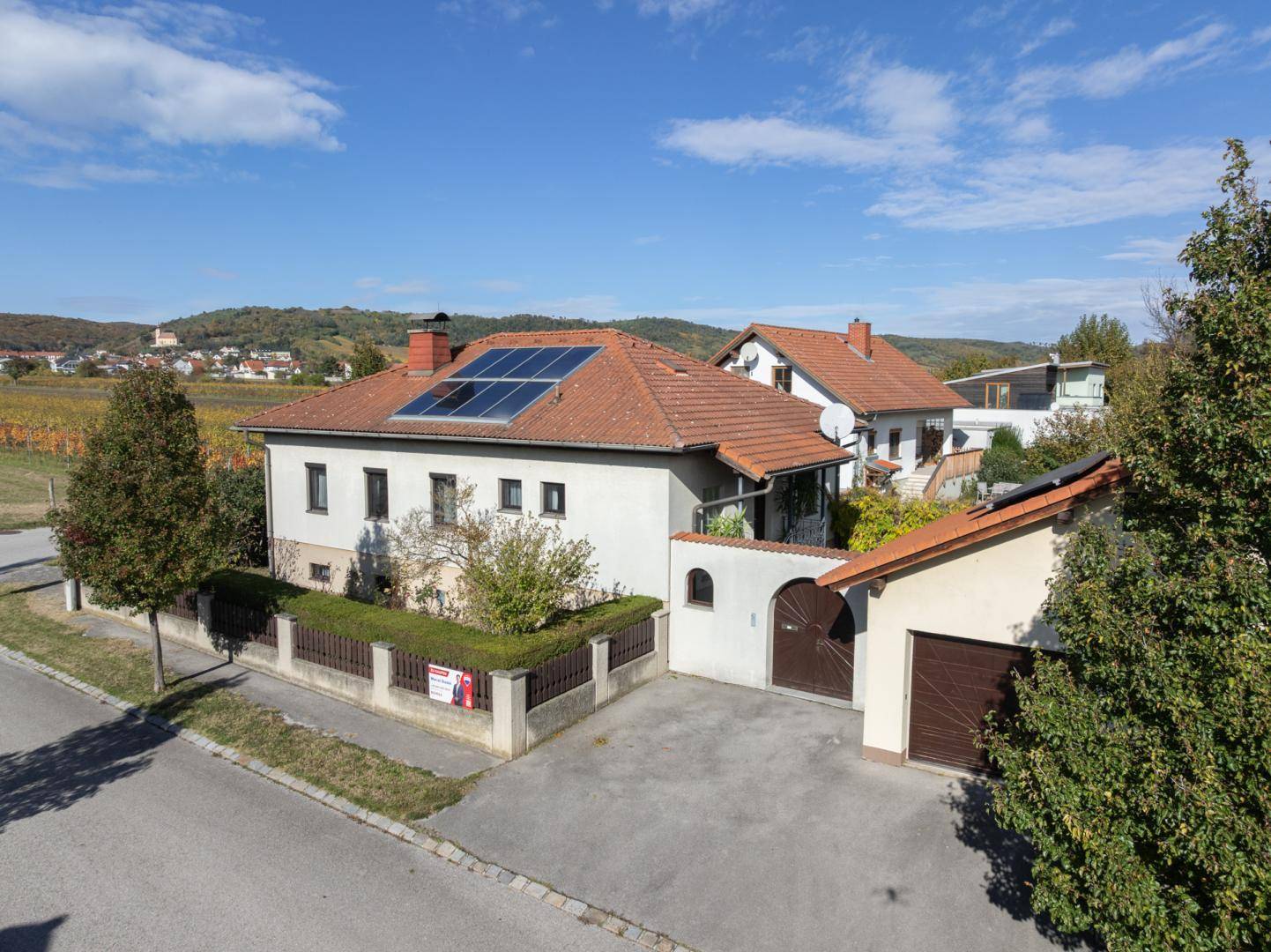 Luftaufnahme des Hauses von vorne mit Photovoltaikanlage und Blick auf die umliegende Landschaft.