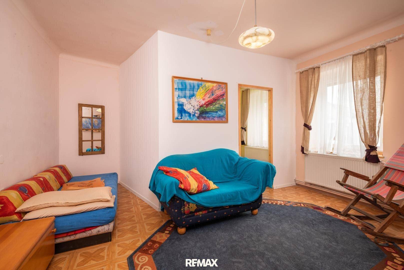 Wohnzimmer mit farbenfrohen Möbeln, Teppich und gemustertem Boden.