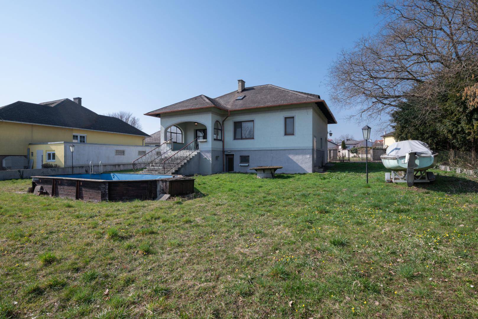 Rückansicht des Hauses mit Garten, Aufstellpool und angrenzenden Nachbargrundstücken.