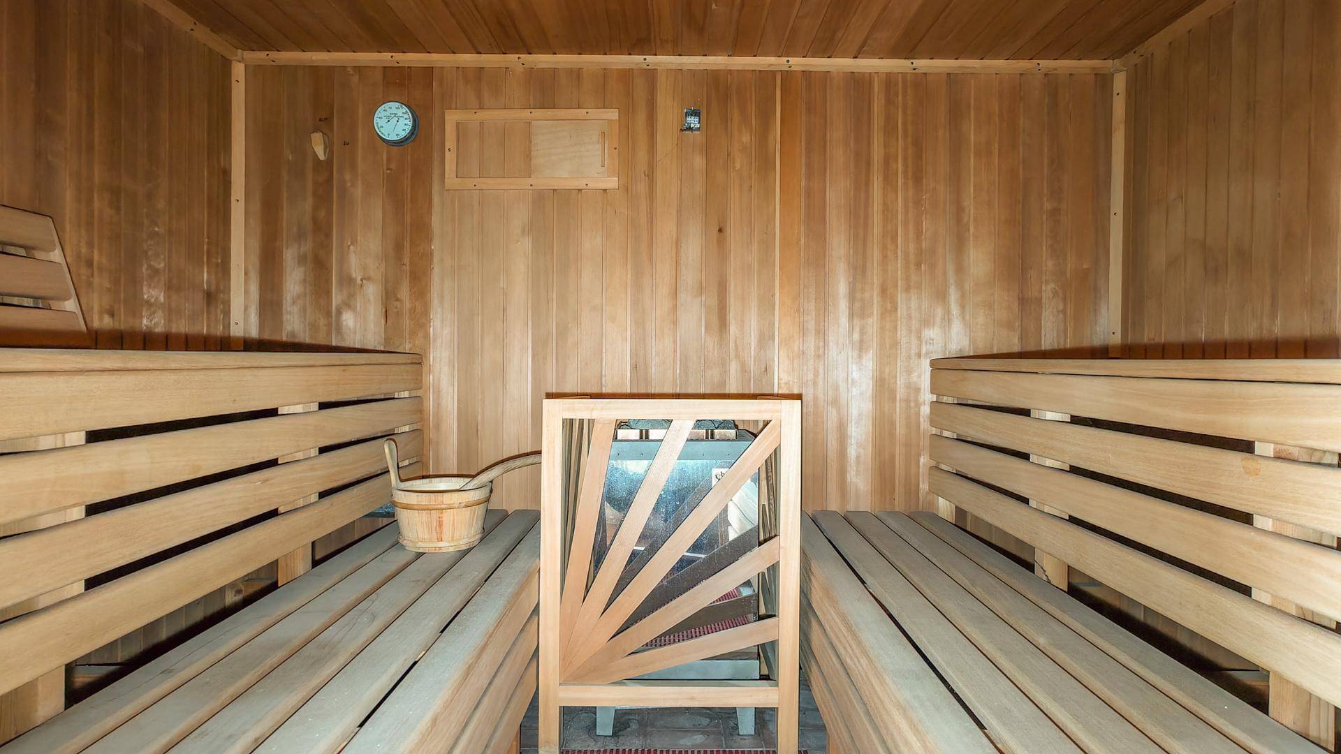 Traditionelle Holzsauna mit Bänken und Saunaofen, ideal zur Entspannung.