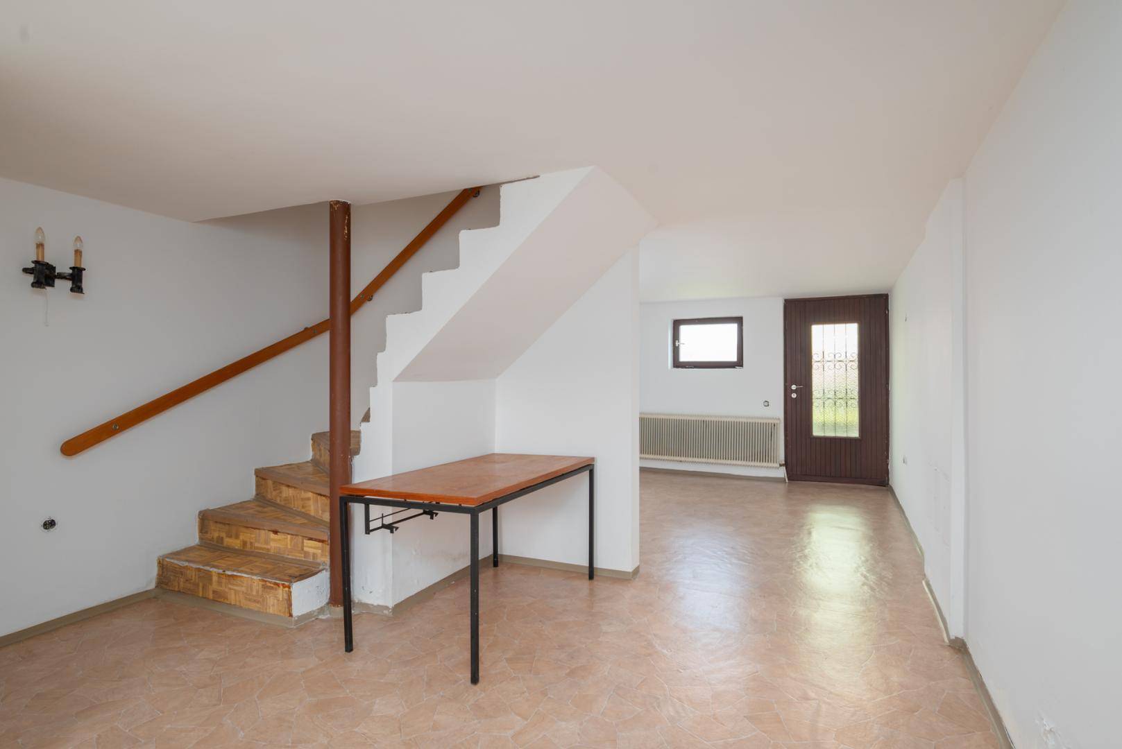 Geräumiger Raum im Untergeschoss mit Treppe und Fliesenboden, vielseitig nutzbar.