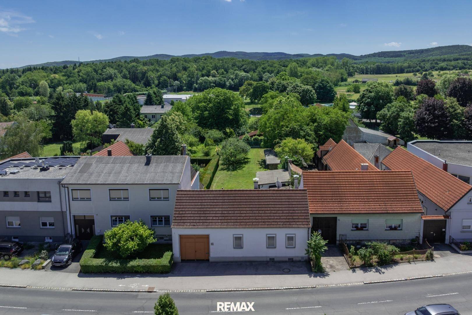 Luftaufnahme des Hauses mit großem Garten und grüner Umgebung, umgeben von weiteren Wohnhäusern.