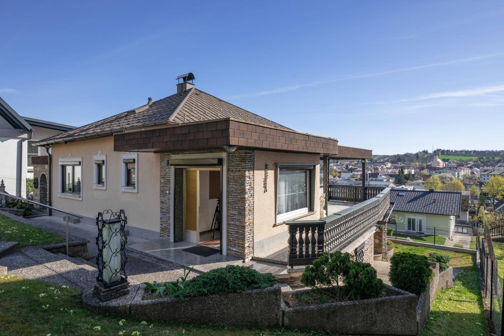 Seitenansicht des Hauses mit Balkon und Blick auf die umliegende Landschaft.