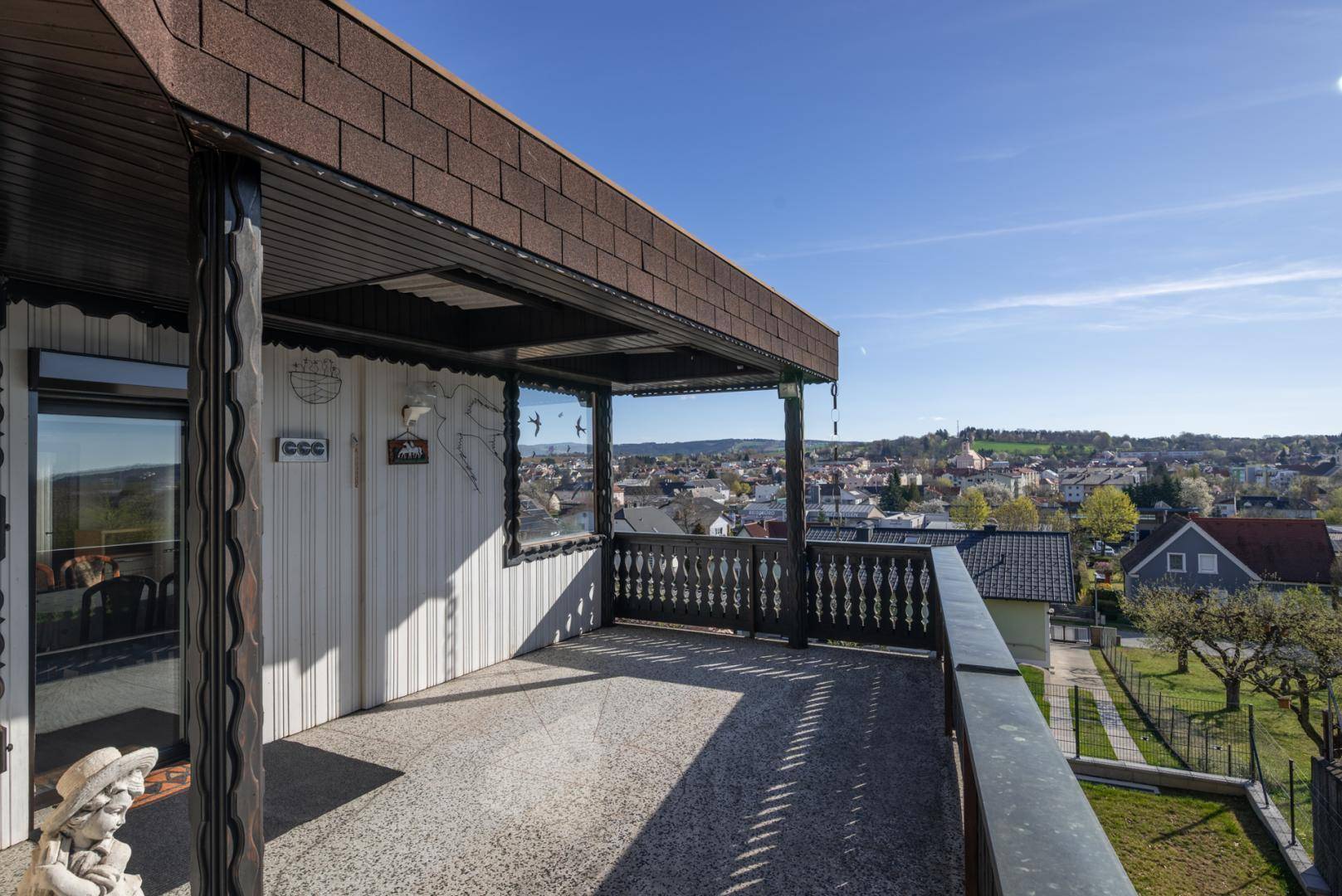 Geräumiger Balkon mit traditionellem Geländer und weitem Blick über die Stadt und Landschaft.