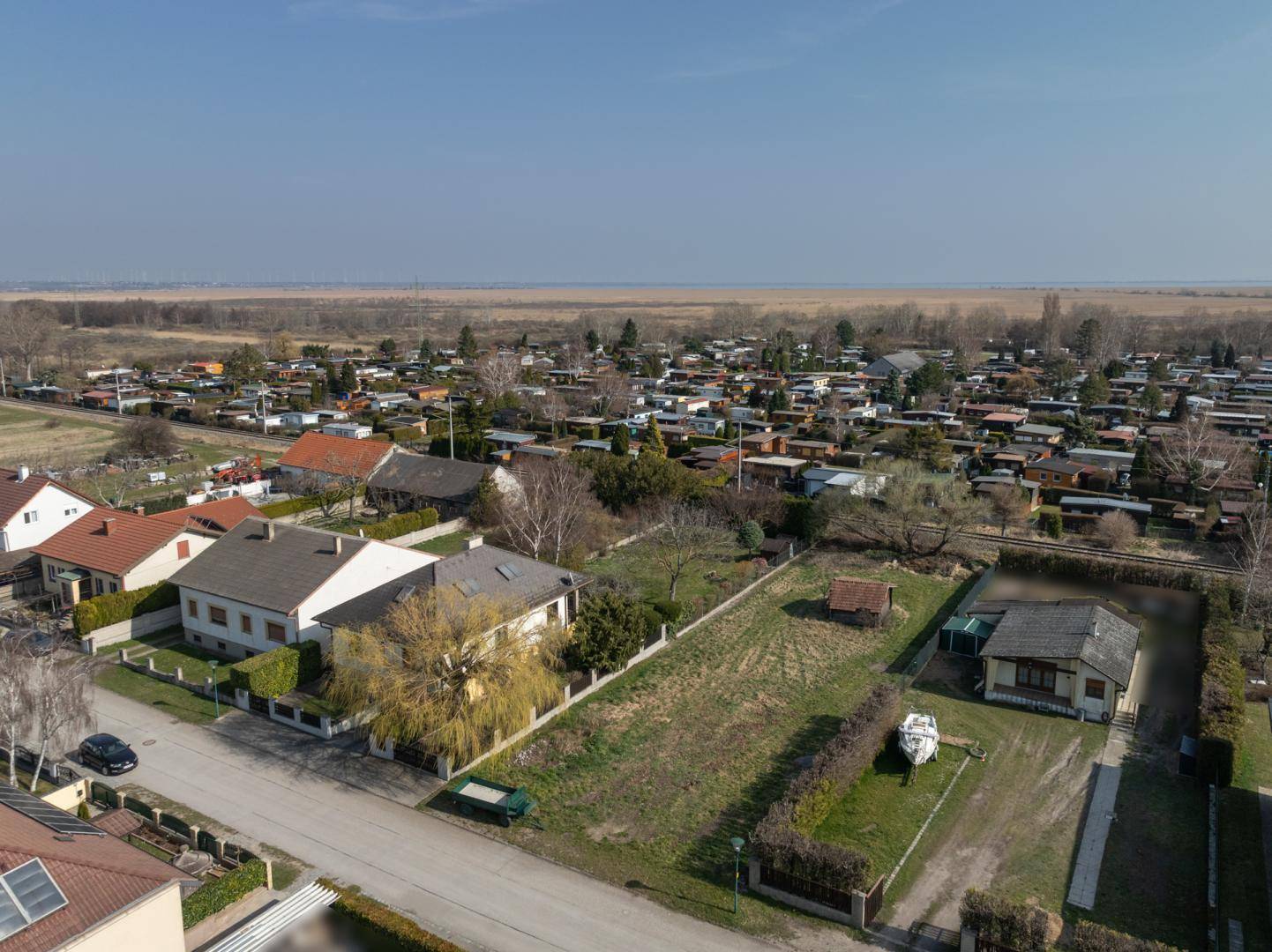 Panoramablick auf ein Grundstück in einer Wohnsiedlung mit weitem Blick über die flache Landschaft.