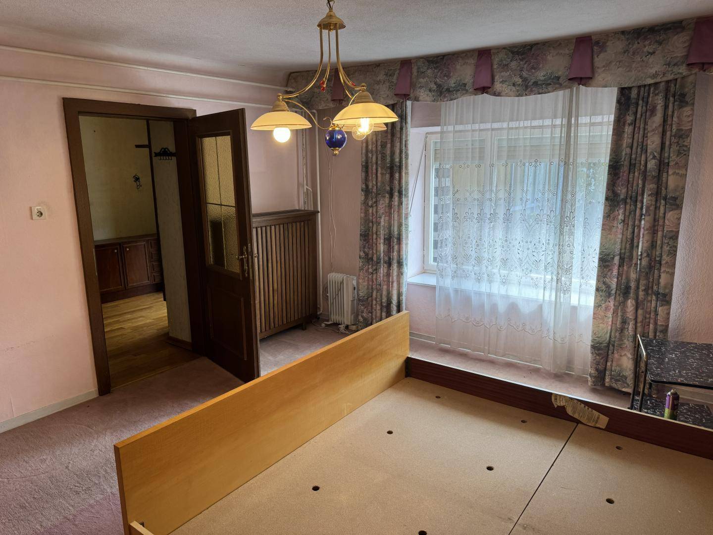 Schlafzimmer mit Teppichboden, Fenster und traditioneller Einrichtung.
