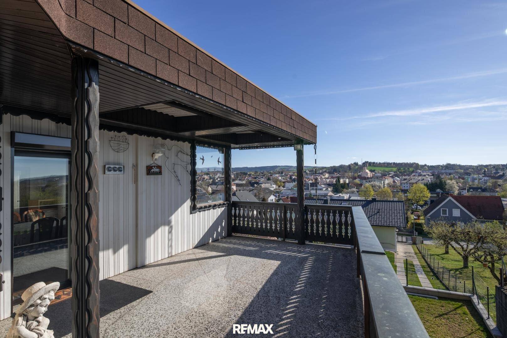Geräumiger Balkon mit traditionellem Geländer und weitem Blick über die Stadt und Landschaft.