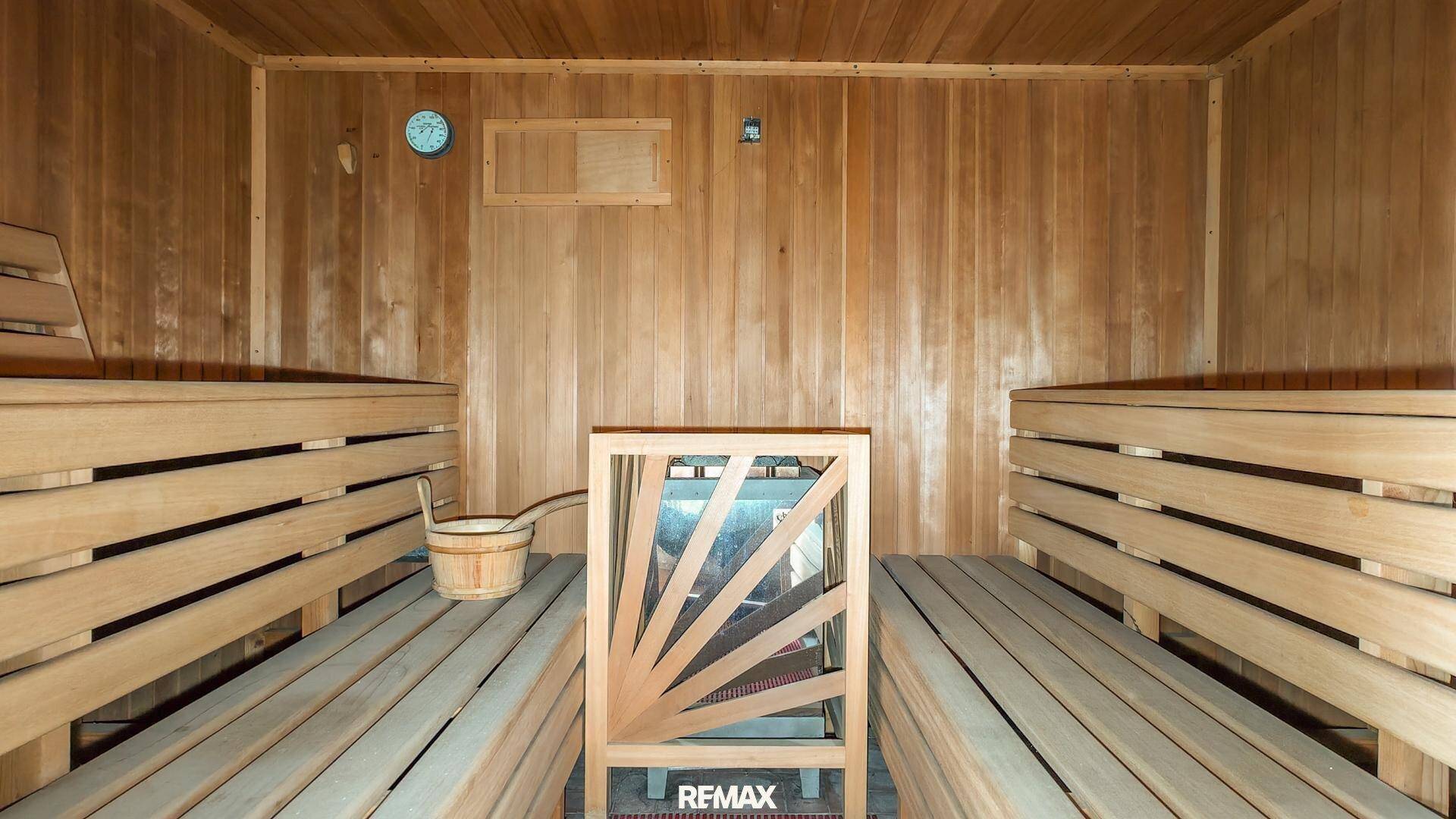 Holzvertäfelte Sauna mit Bänken und Saunaofen, ideal zur Entspannung.