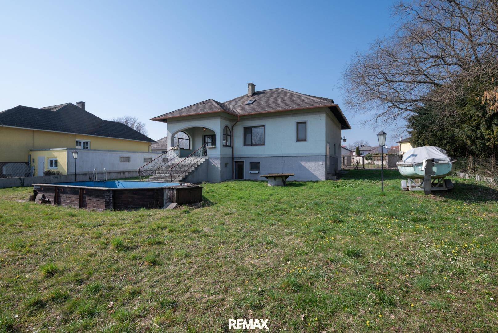 Weitläufiger Gartenbereich mit Aufstellpool und Blick auf die Rückseite des Hauses.