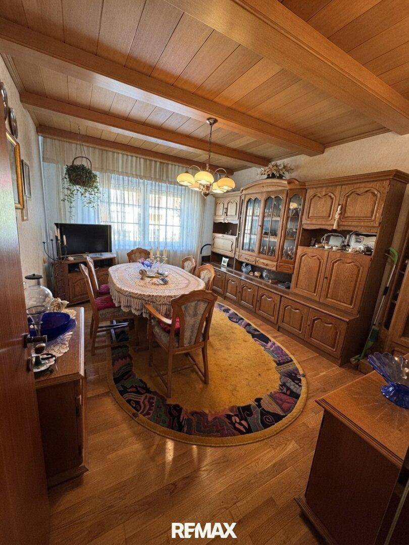 Traditioneller Essbereich mit Holzbalkendecke, großem Holztisch und passenden Holzschränken im Landhausstil.