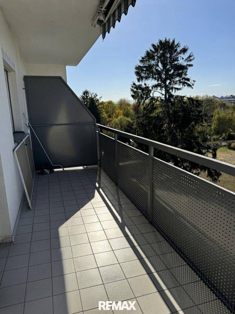 Langer Balkon mit Fliesenboden und Metallgeländer, ideal für entspannte Stunden im Freien.