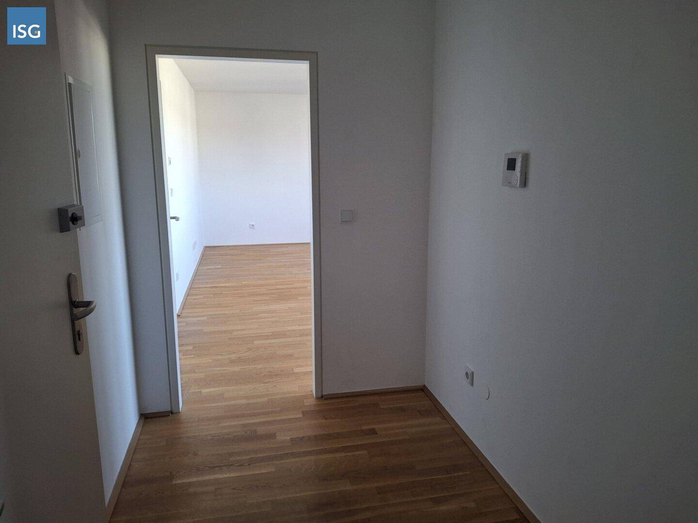 Heller Flur mit Parkettboden, der zu weiteren Zimmern der Wohnung führt.