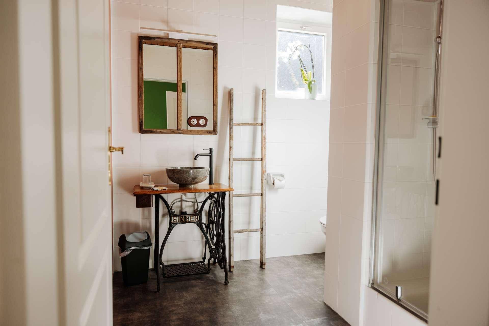 Modernes Badezimmer mit einzigartigem Waschtisch aus einer Nähmaschine und einer Duschkabine.