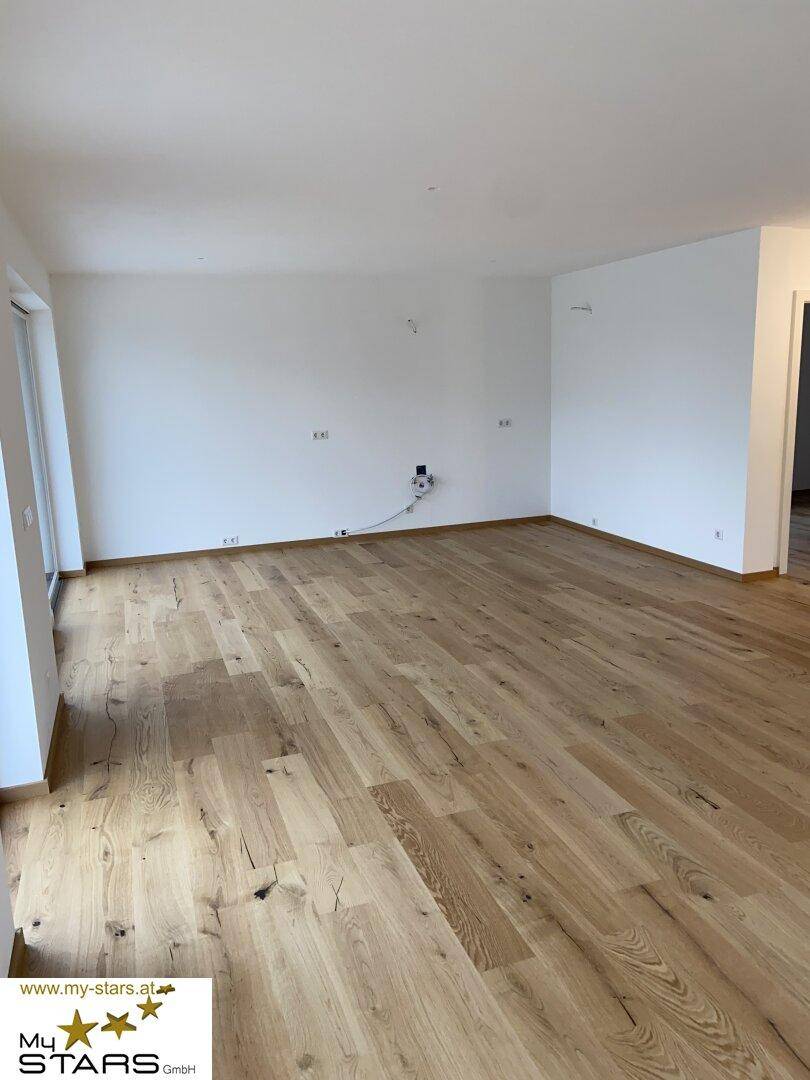 Geräumiger, heller Raum mit ansprechendem Holzboden und weißen Wänden, bereit zur individuellen Gestaltung.