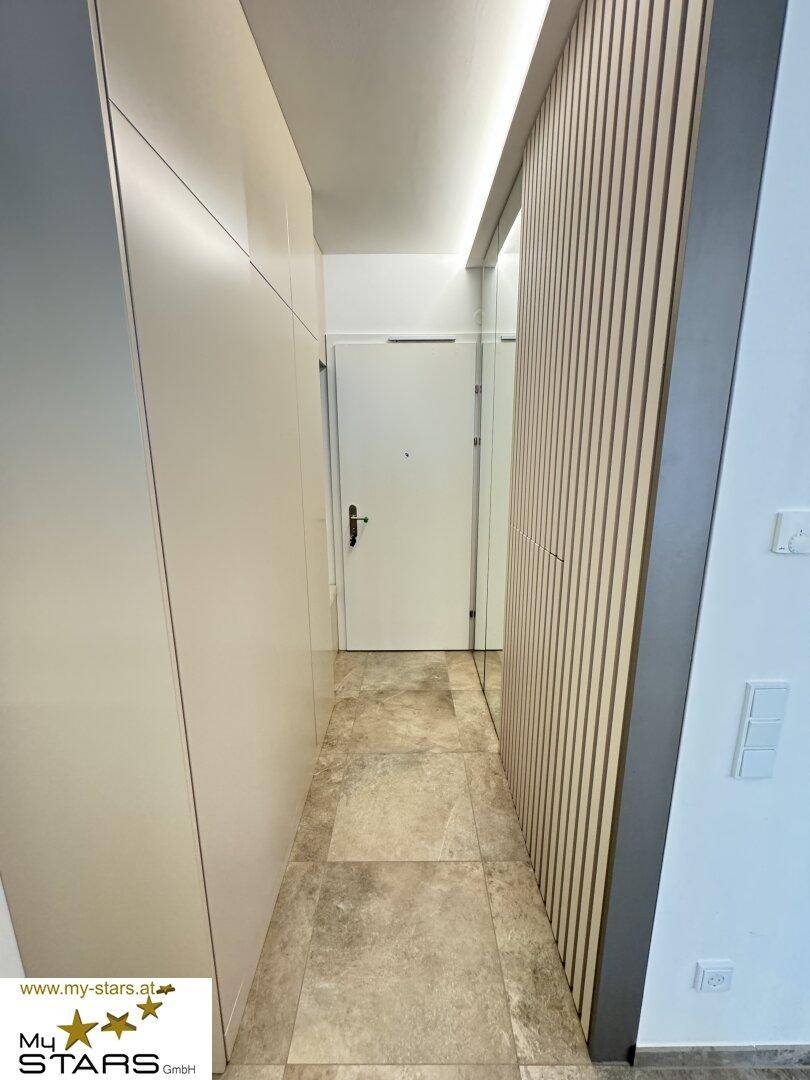 Heller Eingangsbereich mit Einbauschränken und modernem Design.