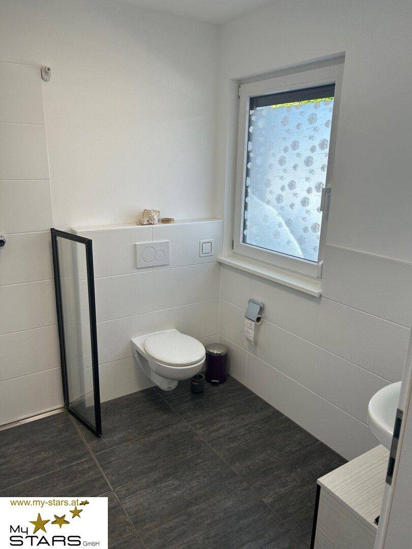 Kleines Badezimmer oder Gäste-WC mit Toilette, Waschbecken und Fenster.