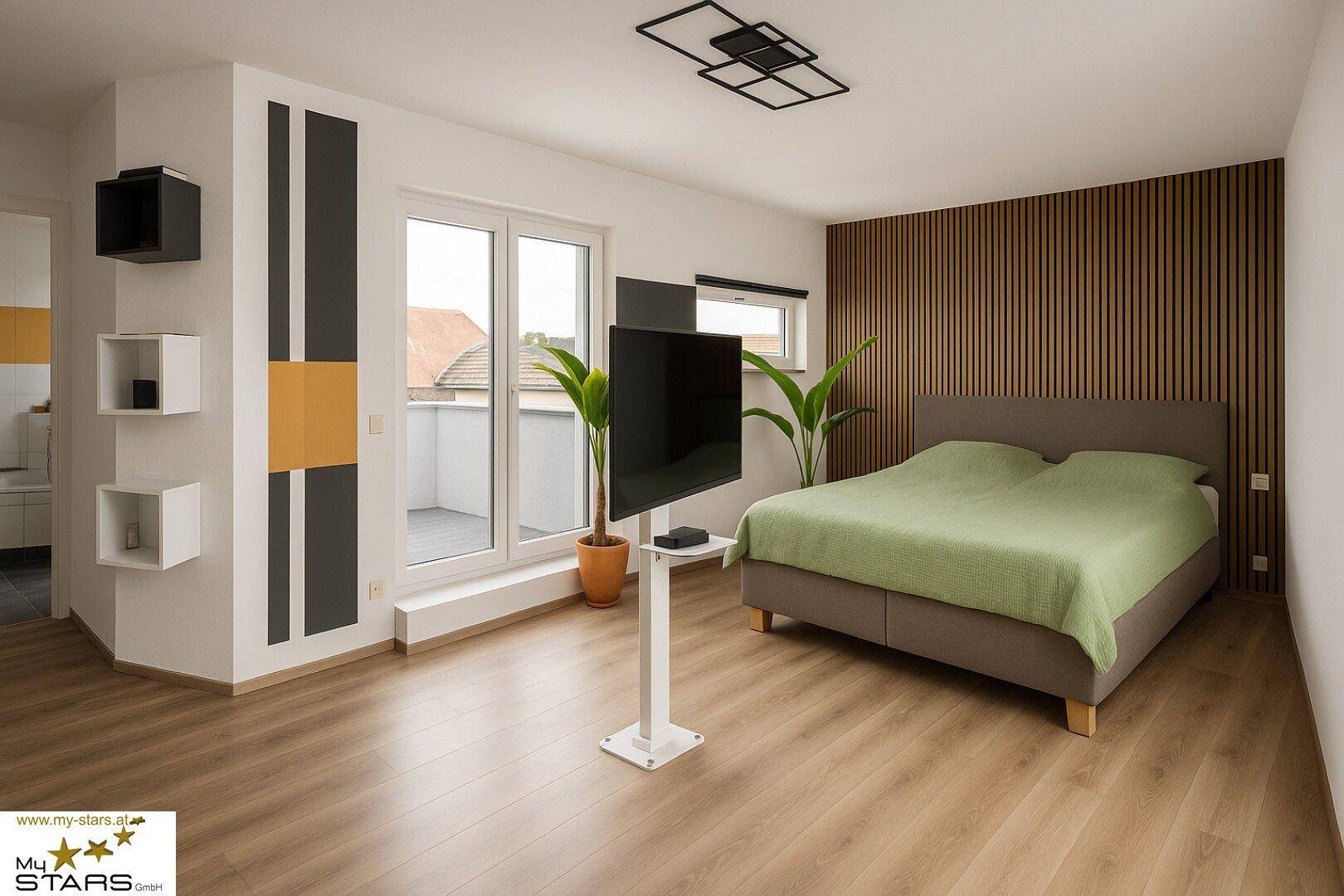 Modernes Schlafzimmer mit Holzwandverkleidung, Balkonzugang und großem Doppelbett.