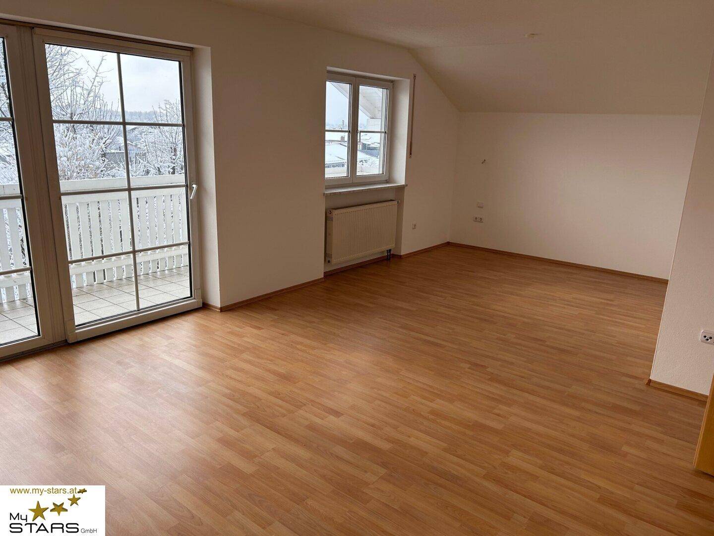 Geräumiges Zimmer mit Laminatboden und Balkonzugang, ideal als Schlafzimmer.