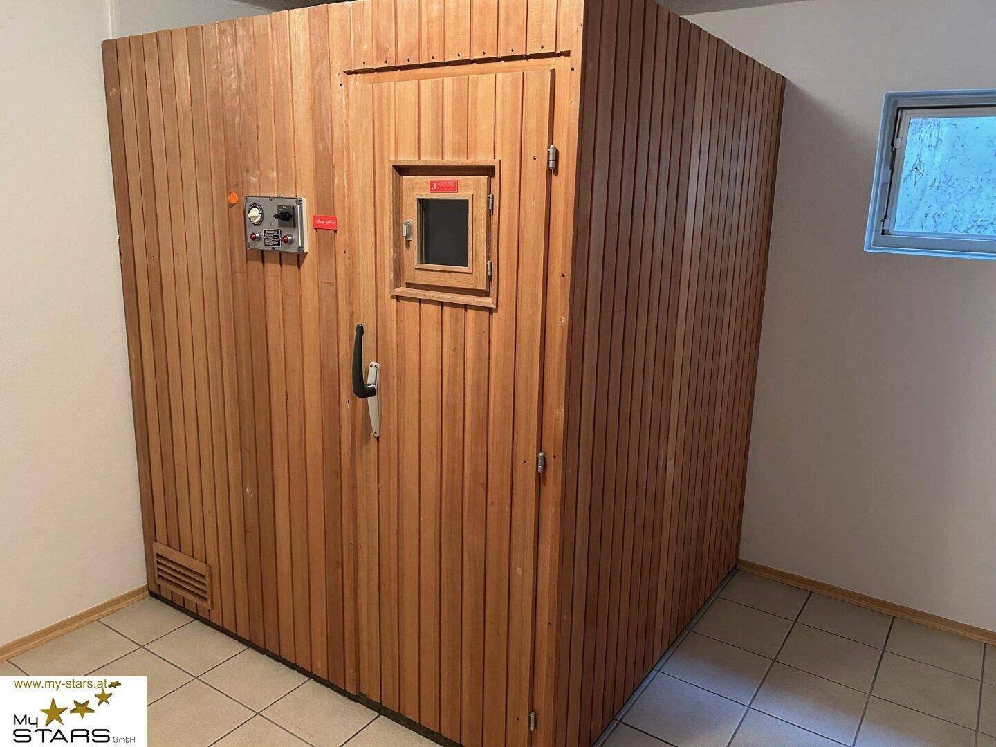 Private Sauna aus Holz mit Steuerungselementen, ideal zur Entspannung.
