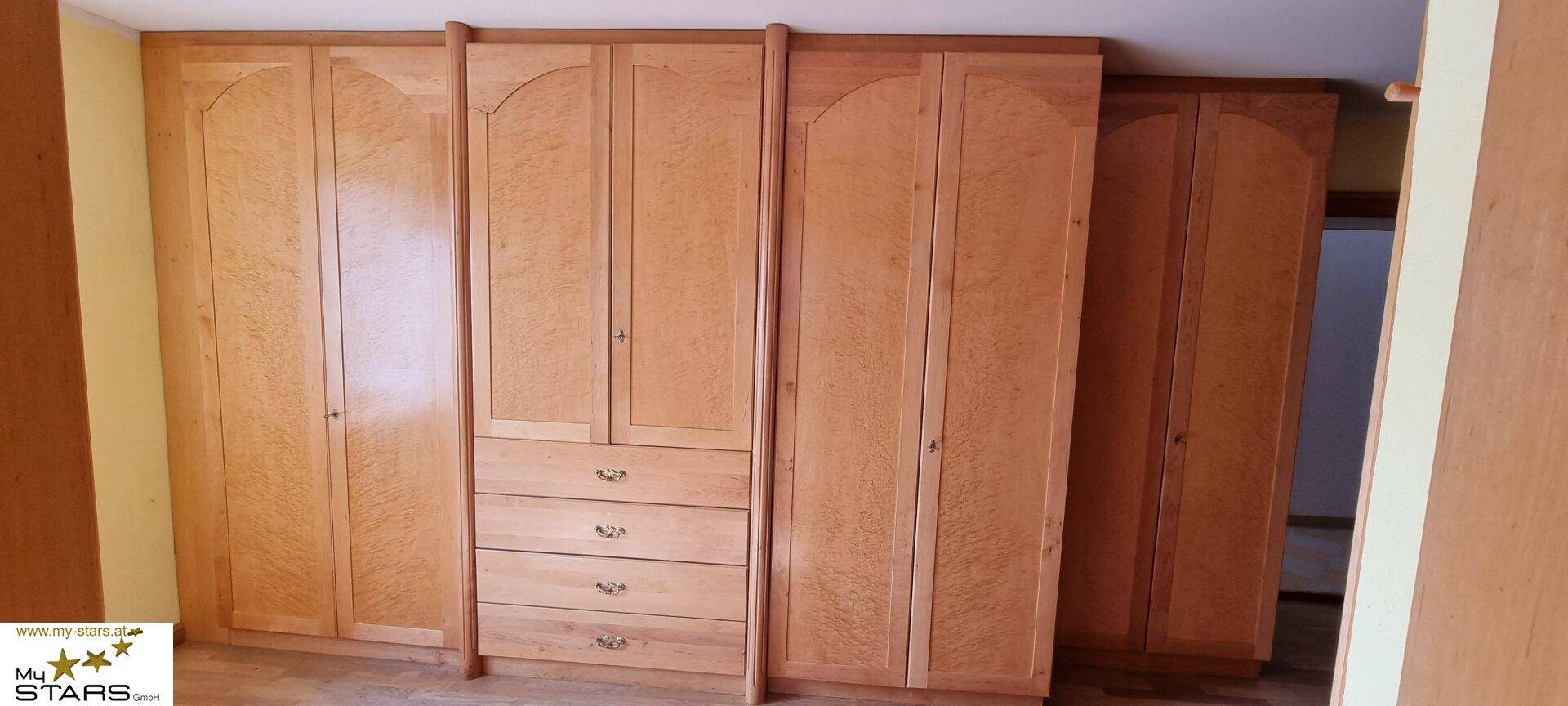 Große Holzschränke mit gewölbten Türen bieten viel Stauraum in diesem Zimmer.