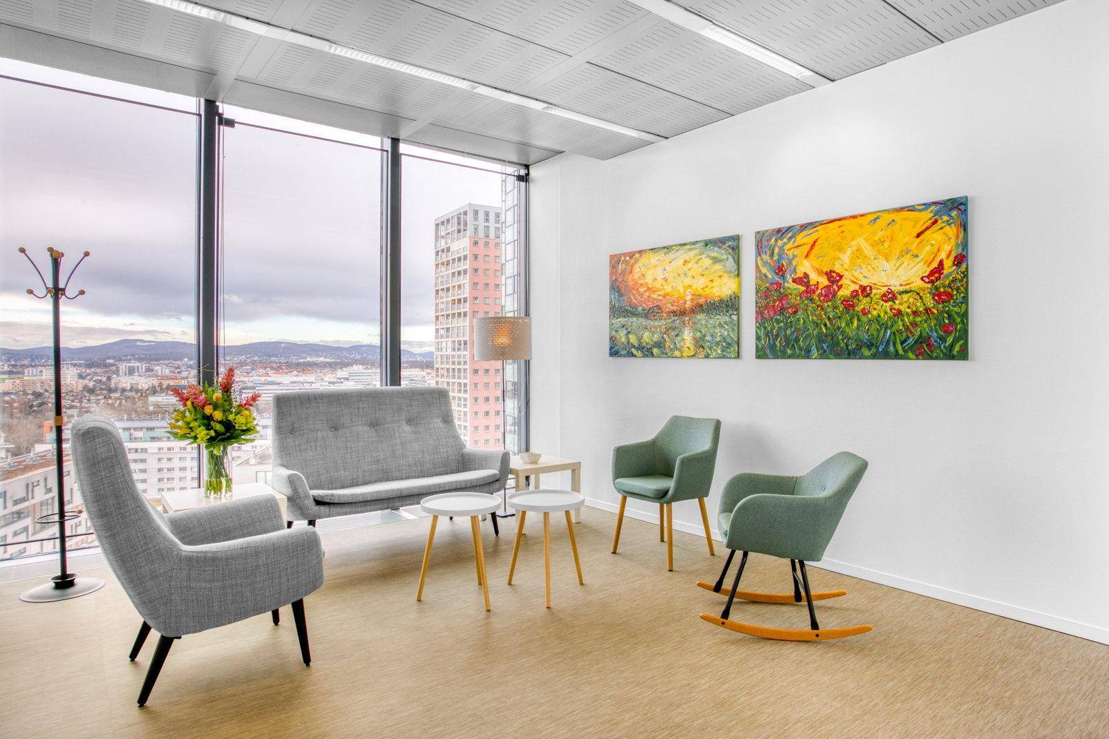 Gemütlicher Loungebereich mit modernen Möbeln, farbenfrohen Bildern und weitem Ausblick.
