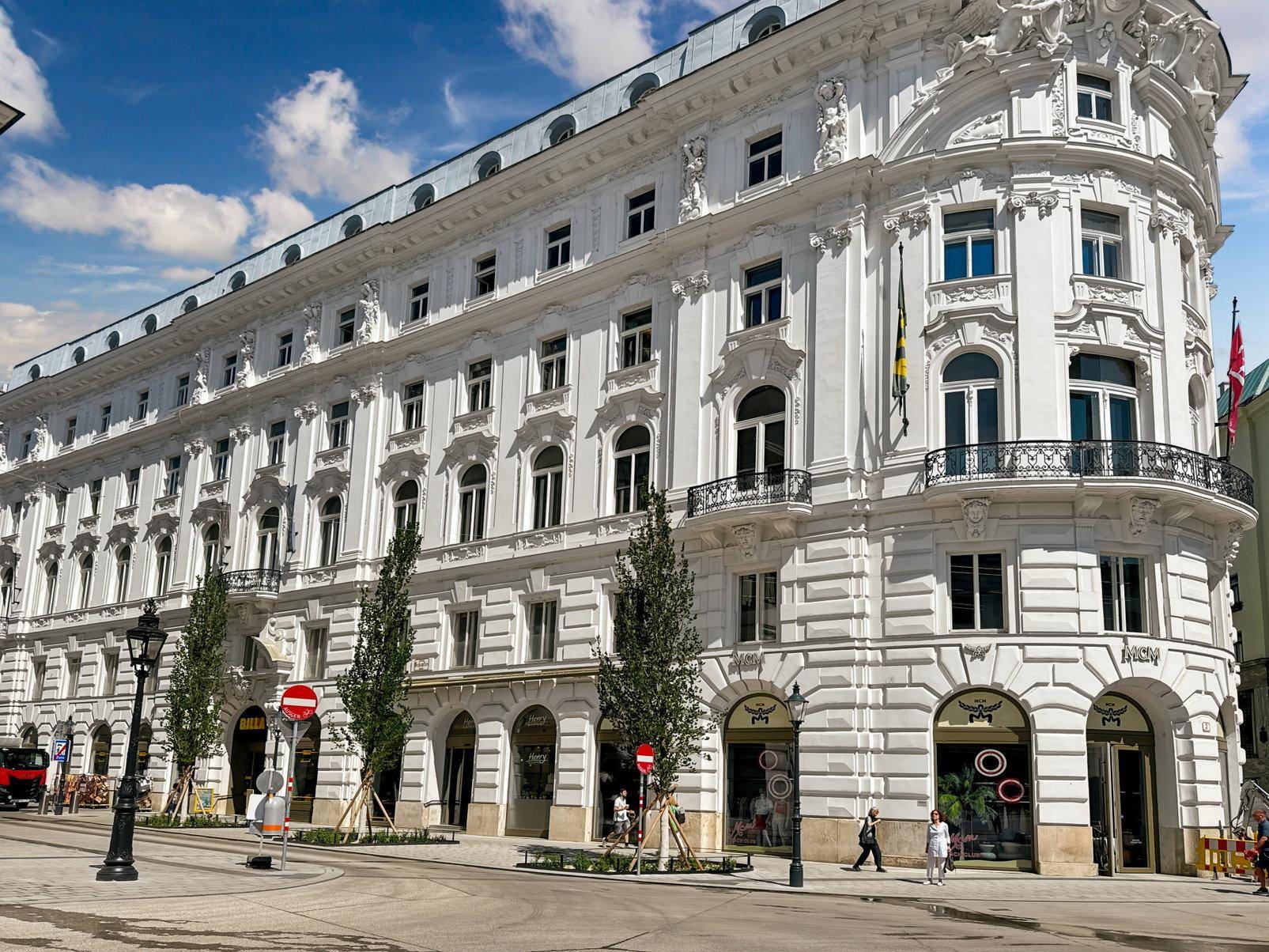 Prächtiges, weißes Gebäude mit klassischer Architektur, reich verzierten Fassaden und großen Fenstern an einer Stadtstraße.