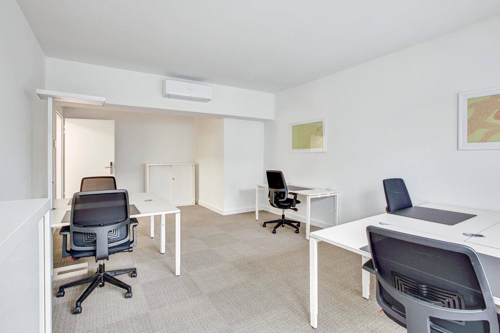 Helles Büro mit mehreren Arbeitsplätzen, Teppichboden und Klimaanlage für eine komfortable Arbeitsumgebung.