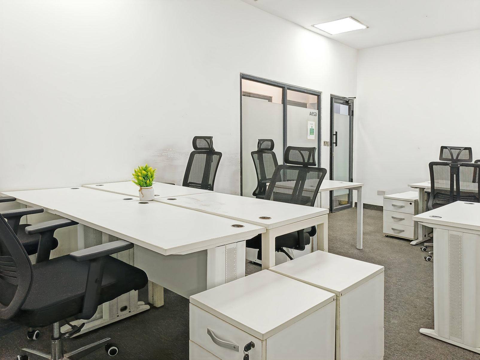 Helles Büro mit mehreren Arbeitsplätzen, ergonomischen Stühlen und Schränken, ideal für Teamarbeit.